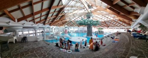 un grupo de personas de pie alrededor de una piscina en un edificio en Sunny Home, en Čatež ob Savi