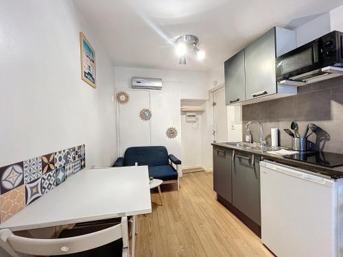 une cuisine avec un comptoir blanc et une table dans l'établissement L'Authentique Panier - Central & Calme - Les Frères de la Loc', à Marseille