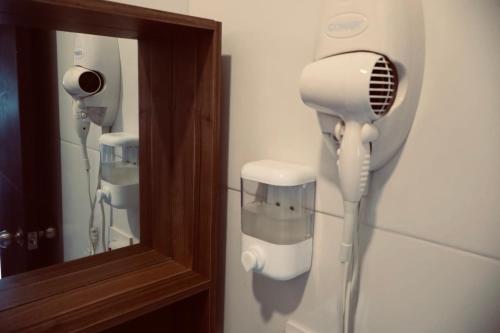 a bathroom with a hair dryer and a mirror at BHB - ApartaHotel in Leticia