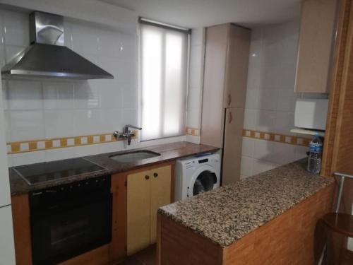 a small kitchen with a sink and a dishwasher at ACOGEDOR PISO EN CULLERA JUNTO AL MAR in Cullera
