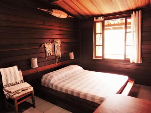 烏巴圖巴的住宿－Casa Ubatuba Vista para o Mar，卧室配有床、椅子和窗户。