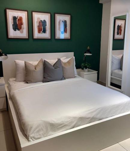 a large white bed in a bedroom with green walls at Hotel bienvenida in Los Tres Brazos