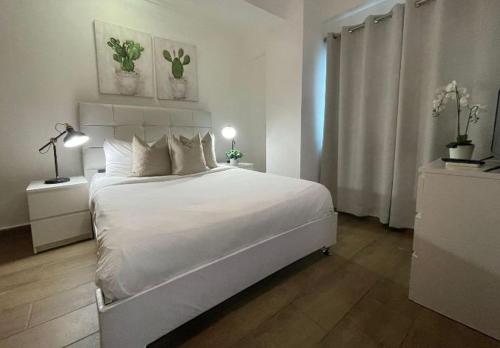 a white bedroom with a large bed and a window at Hotel bienvenida in Los Tres Brazos
