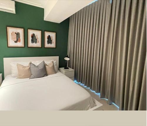 ein Schlafzimmer mit einem weißen Bett und grünen Wänden in der Unterkunft Hotel bienvenida in Los Tres Brazos