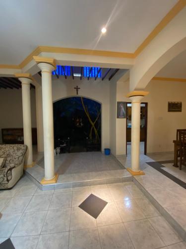 a living room with columns and a fireplace at The Serene House in Negombo