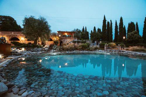 una gran piscina de agua con rocas en un patio en Agriturismo Pratello, en Padenghe sul Garda