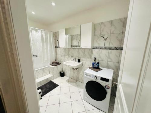 a bathroom with a washing machine and a sink at Exclusive apartment for families and business in Uster