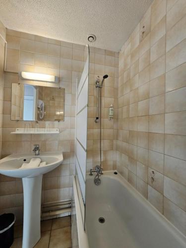 埃塔普勒的住宿－艾斯卡爾酒店，浴室配有盥洗盆和浴缸。