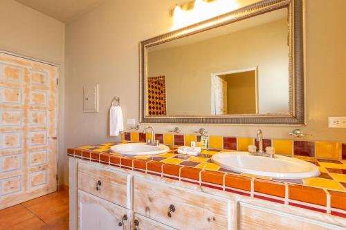a bathroom with two sinks and a large mirror at Cerritos Surf Town - Beach Front Property in El Pescadero