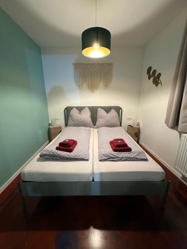 una camera da letto con un letto con due cuscini rossi sopra di Relaxen im Weindorf Mayschoß Fewo 1 a Mayschoss