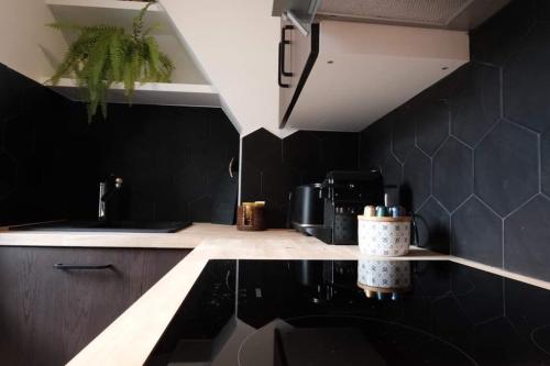 une cuisine avec des murs noirs et un comptoir noir dans l'établissement Studio Cannes - 5mn Palais des Festivals (400m), à Cannes