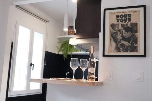 une étagère avec deux verres à vin et une affiche dans l'établissement Studio Cannes - 5mn Palais des Festivals (400m), à Cannes