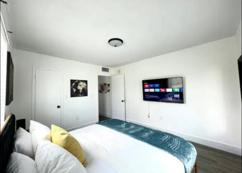 a bedroom with a bed and a tv on the wall at Miami International Airport 2 in Miami