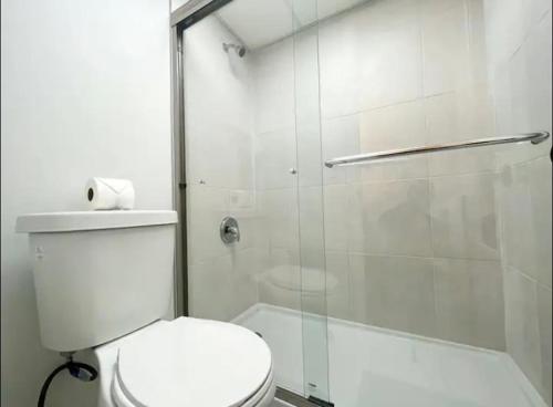 a bathroom with a toilet and a glass shower at Miami International Airport 2 in Miami
