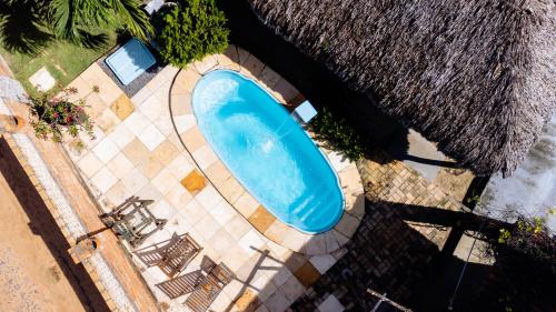 an overhead view of a blue swimming pool with chairs at Pousada Villa Aruna in Barra Grande