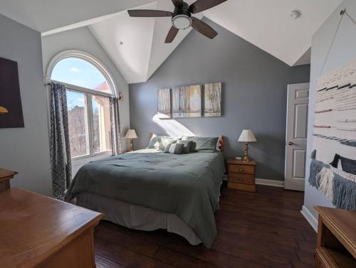 a bedroom with a bed and a ceiling fan at Relaxing Condo on the River - NEW Air Hockey Table in Pigeon Forge