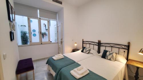 a bedroom with a bed and a desk and windows at Magdalena Plaza City Center 1º in Seville