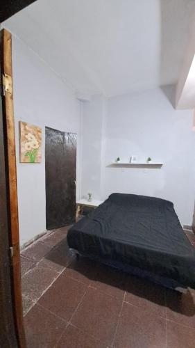 a bedroom with a bed in the corner of a room at Delfina -Catamarca, Zona Centro in San Fernando del Valle de Catamarca
