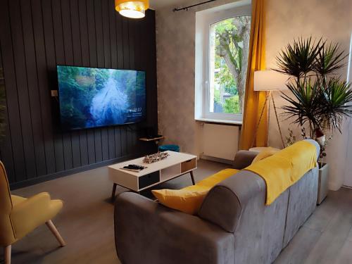 a living room with a couch and a tv at Villa Garona avec billard proche Pyrénées in Cazères
