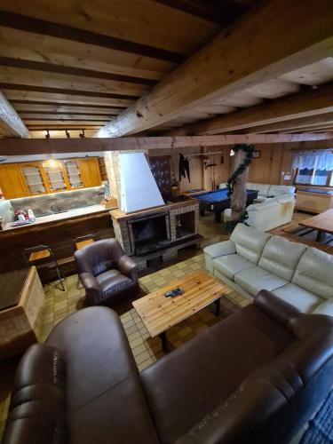 a living room with leather furniture and a fireplace at Chata pri Veľkej Rači in Oščadnica