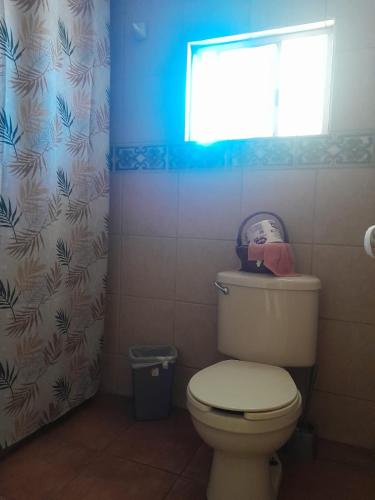 a bathroom with a toilet and a window at Casa de Ana in Tijuana
