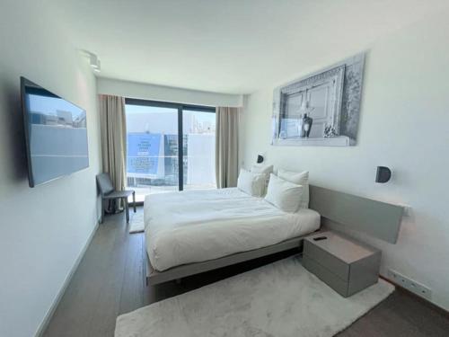 une chambre blanche avec un lit et une télévision dans l'établissement Appartement Cannes 4 chambres - 523, à Cannes