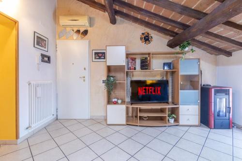a living room with a television and a refrigerator at Ferrari Museum & Train Station - Il Cavallino Loft in Modena