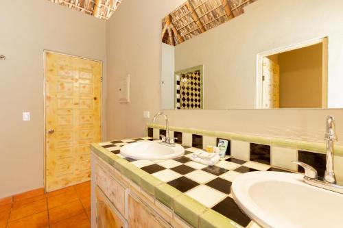 a bathroom with two sinks and a large mirror at Cerritos Surf Town - Beach Front Property in El Pescadero
