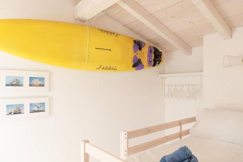 a surfboard hanging on a wall in a room at La Vela Summer House - FREE WIFI - 700mt from the beach in Costa Rei