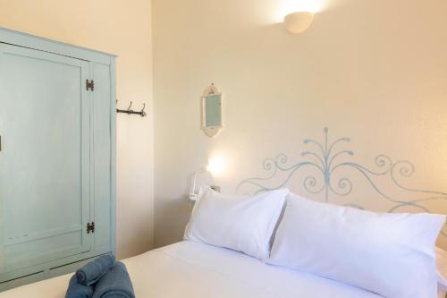 a bedroom with a bed with white pillows at La Vela Summer House - FREE WIFI - 700mt from the beach in Costa Rei