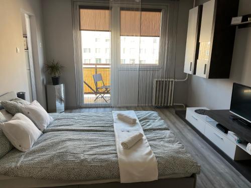 um quarto com uma cama grande e toalhas em PV Apartman em Miskolc