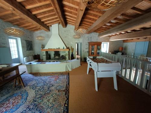un salon avec une table et une cheminée dans l'établissement Le Moulin de La Grave - Lagrasse, à Lagrasse