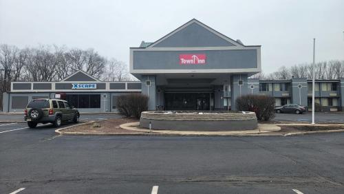 ein Auto, das vor einem Gebäude mit einem Einkaufszentrum parkt in der Unterkunft Town Inn in Bordentown