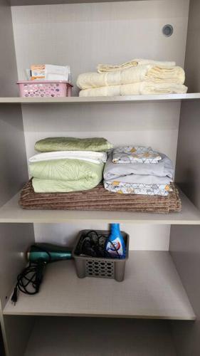 a white closet with towels and a basket and a shelf at Confortável Studio no Park Sul próximo ao aeroporto in Brasília
