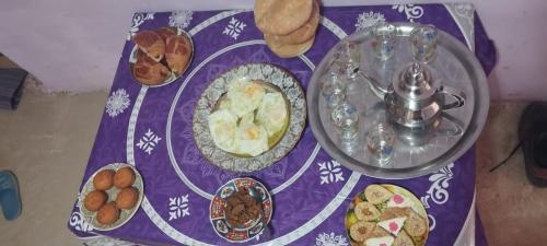 einen Tisch mit einem lila Tischtuch mit Essen drauf in der Unterkunft Ketama hachiche in Tlata Ketama