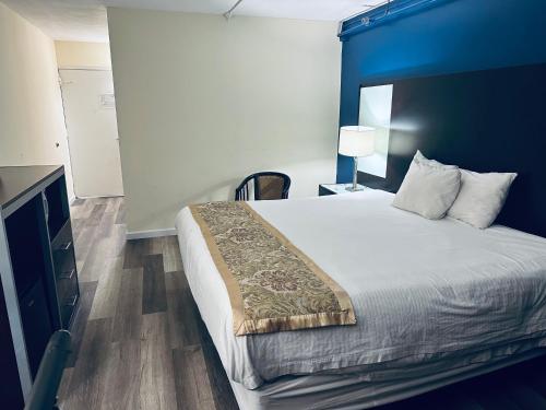a bedroom with a large bed with a blue wall at Town Inn in Bordentown