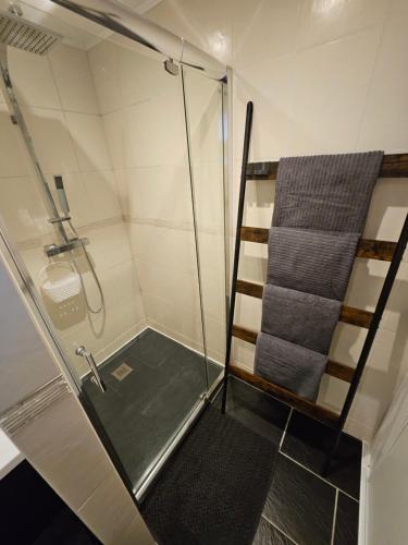 a shower with a glass door and a towel at Gîte Vallée de Munster chez Flavie & Ludo in Muhlbach-sur-Munster