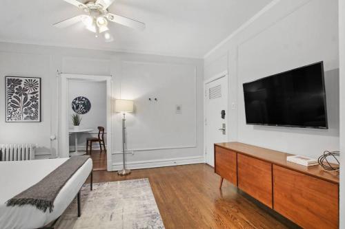 a bedroom with a bed and a flat screen tv at Modern and Minimalist Studio Apartment - Bstone 105 and 108 rep in Chicago