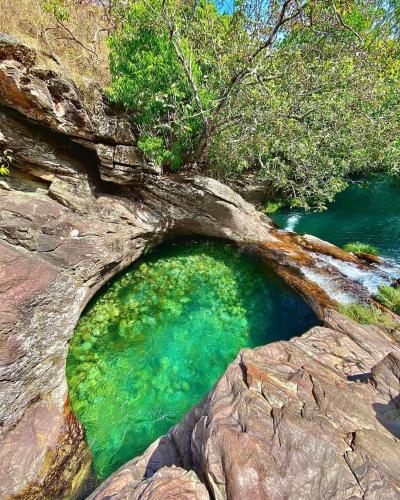 a rock cave with a green pool of water at Pousada Recanto do Tucano in Cavalcante