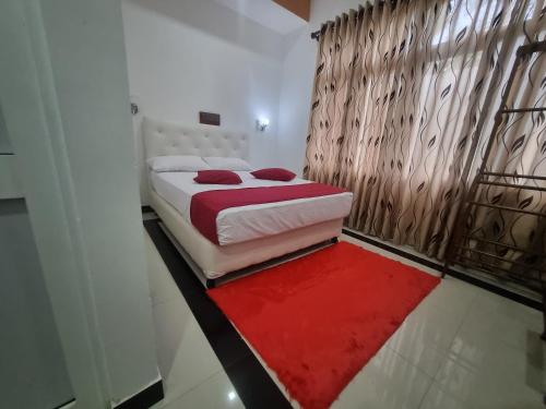 um quarto com uma cama e um tapete vermelho em NEW LAYA NEEM RESORT AND RESTAURANT em Dambulla