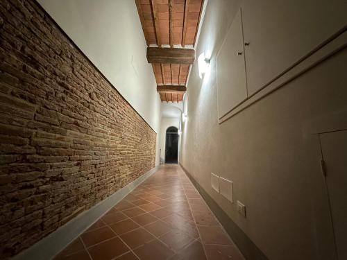 an empty hallway with a brick wall and a corrid at Casa Stefi Belfioreguesthouses in Pontedera