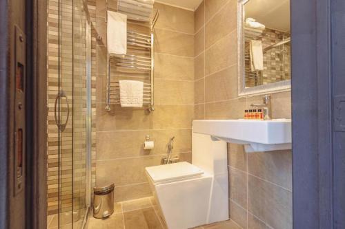 La salle de bains est pourvue de toilettes et d'un lavabo. dans l'établissement VİVA BOUTIQUE & MIRROR DELUXE HOTEL's BAKU, à Baku
