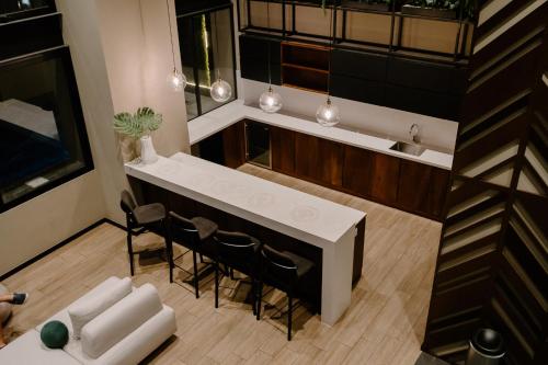 an overhead view of a kitchen with a counter and chairs at Exclusivo, lujoso y nuevo apartamento en zona 10 in Guatemala