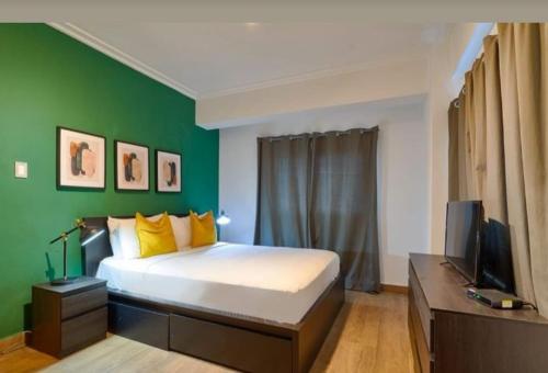 zieloną sypialnię z łóżkiem i telewizorem w obiekcie Hotel bienvenida w mieście Los Tres Brazos