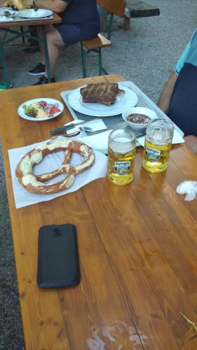a wooden table with food and two glasses of beer at Wellnessoase mit Sauna und Whirlpool in Inzell