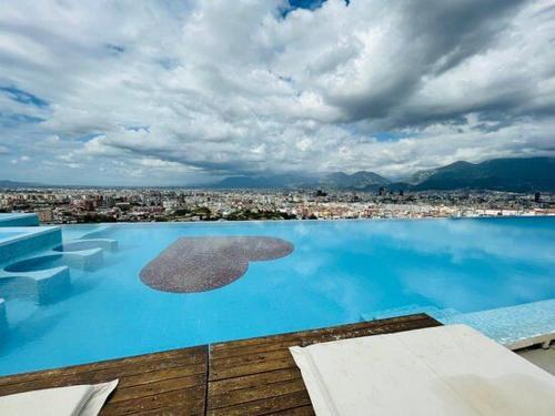 a large swimming pool with a view of a city at Deluxe Flat with garden_Tirana in Tirana