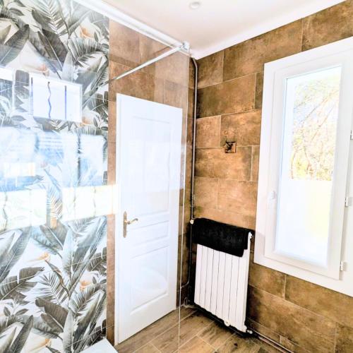 a bathroom with a wall mural of palm trees at Suite de charme provençale in La Valette-du-Var