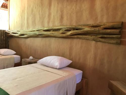 プエルト・マルドナードにあるCasa Amazonasのベッド2台が備わる客室で、壁には絵画が飾られています。