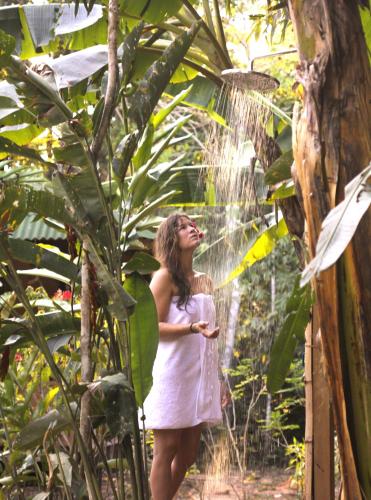 a woman standing in the rain in the jungle at Casa Amazonas in Puerto Maldonado
