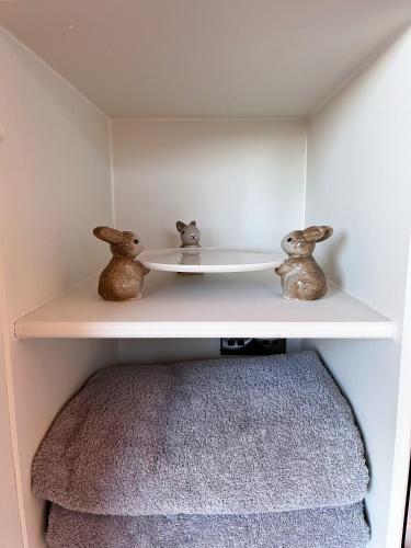 a shelf with two little figurines on top of it at Capledrae Farmstay Shepherds Huts in Cardenden